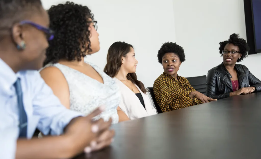 Reverse mentoring with a group of BIPOC employees meeting and discussing around a conference table.