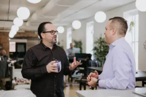 Two men in an office discussion learning agility in succession planning.
