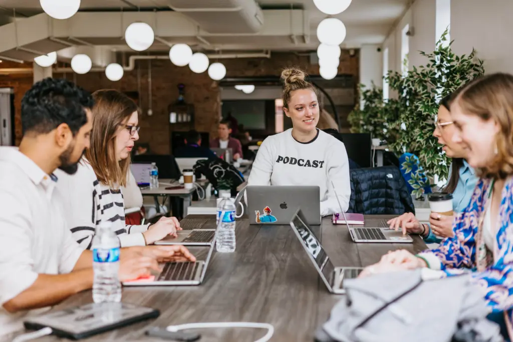 An image of happy employees sitting at a table together.