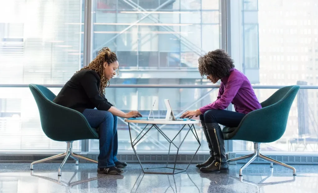 Two people sitting down for workplace mentoring.